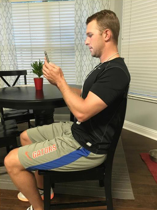 Man using a mobile device while sitting up straight with good posture