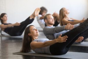 pilates class with people exercising on mats doing pilates 100