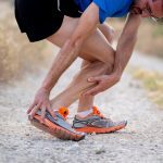 image of runner grabbing twisted ankle injury