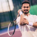 image of male tennis player holding a racquet experiencing elbow pain
