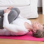 image of woman bringing knees to chest for healthy stretches