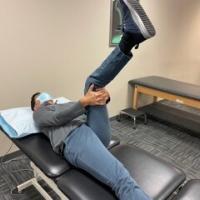 Man on his back performing a 9090 hamstring stretch