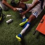 Soccer player injured knee during the game. Sport Doctors provide first aid to player on a professional football field.