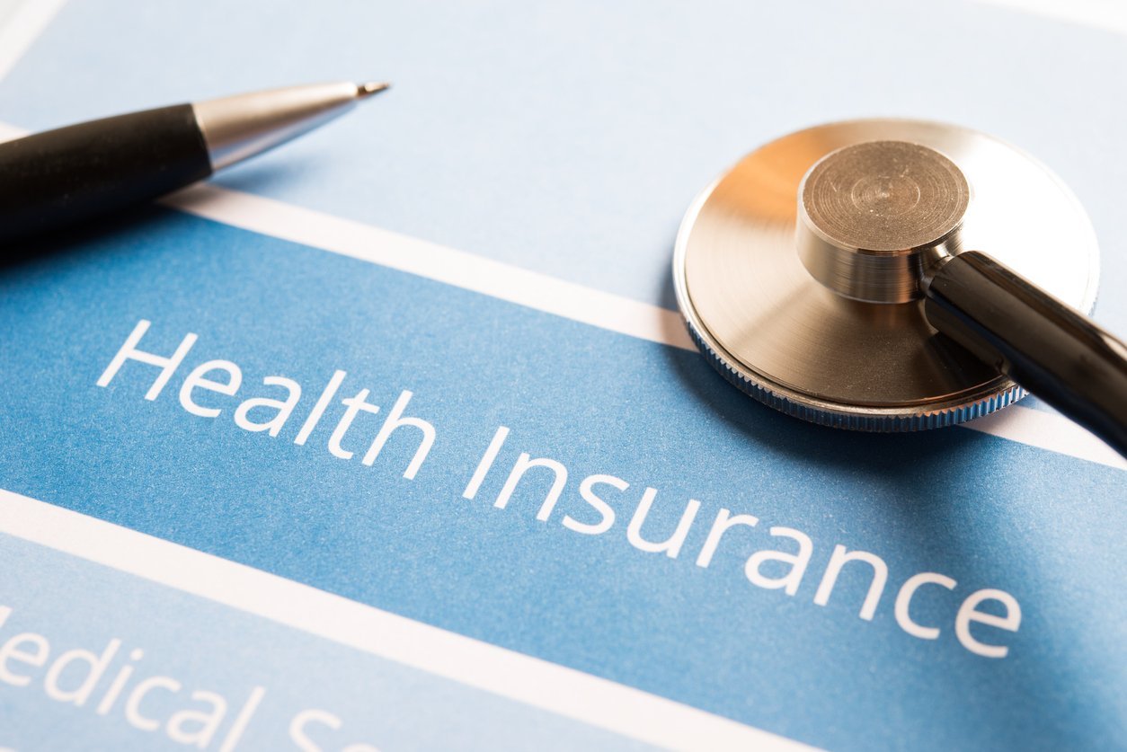 Image of a pen and stethoscope with label reading health insurance